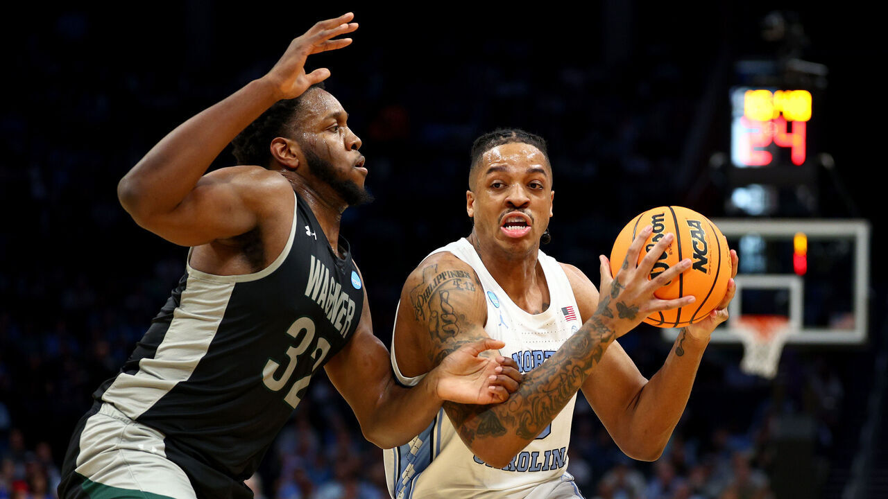 CHARLOTTE, NORTH CAROLINA - MARCH 21: Armando Bacot #5 of the North Carolina Tar Heels drives to the basket against Keyontae Lewis #32 of the Wagner Seahawks during the first half in the first round of the NCAA Men's Basketball Tournament at Spectrum Center on March 21, 2024 in Charlotte, North Carolina.