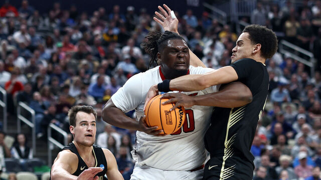 PITTSBURGH, PENNSYLVANIA - MARCH 23: DJ Burns Jr. #30 of the North Carolina State Wolfpack battles for a loose ball against Chris Conway #2 and Jack Gohlke #3 of the Oakland Golden Grizzlies during the second half of a game in the second round of the NCAA Men's Basketball Tournament at PPG PAINTS Arena on March 23, 2024 in Pittsburgh, Pennsylvania.