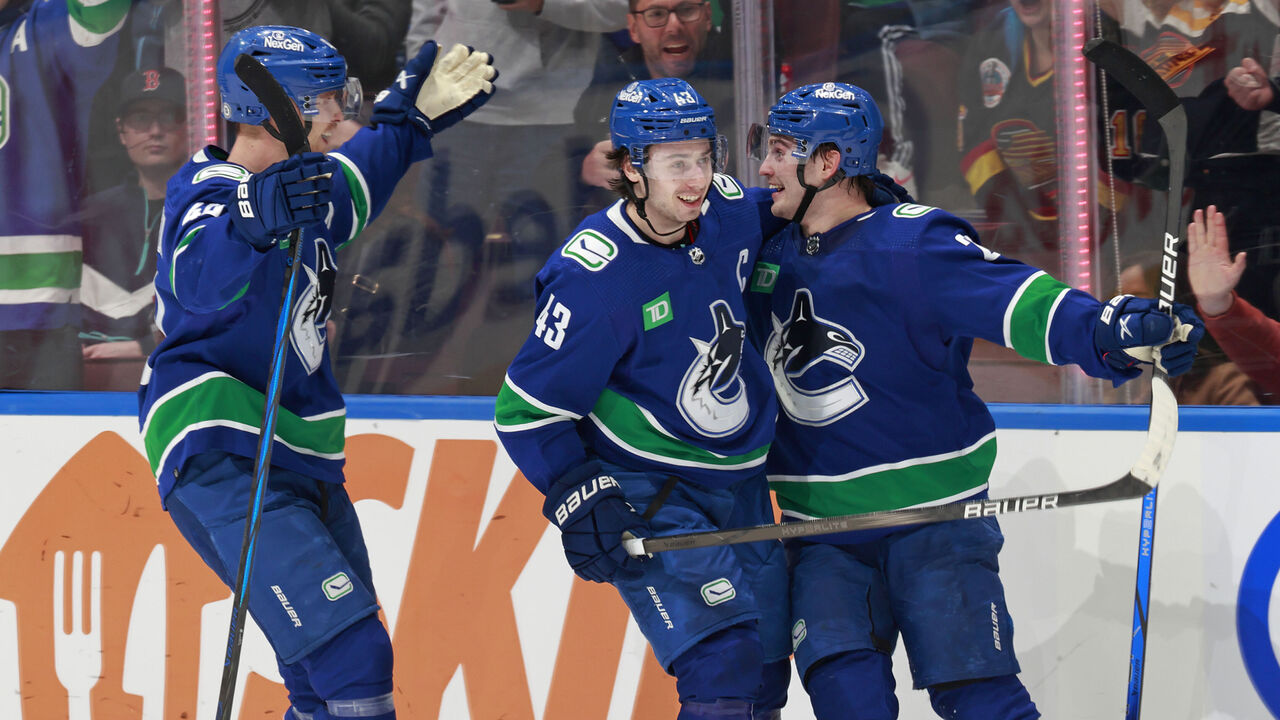 VANCOUVER, CANADA - MARCH 23: Nils Hoglander #21 of the Vancouver Canucks is congratulated by teammates Quinn Hughes #43 and Elias Pettersson #40 after scoring during their NHL game against the Calgary Flames at Rogers Arena on March 23, 2024 in Vancouver, British Columbia, Canada.