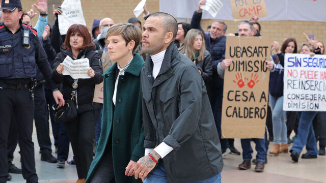Prison workers unions' members protest over the killing of a cook by an inmate the week before, as convicted rapist and former Brazil international football player Dani Alves (R), flanked by his lawyers Ines Guardiola, leaves Brians 2 prison in Barcelona on March 25, 2024. Convicted rapist and former Brazil international Dani Alves left a jail in Barcelona on March 25, 2024 after posting the one-million-euro bail set by a Barcelona court to ensure his release pending appeal. Ex-Brazil star has been sentenced to 4.5 years in jail for rape on February 22, 2024.