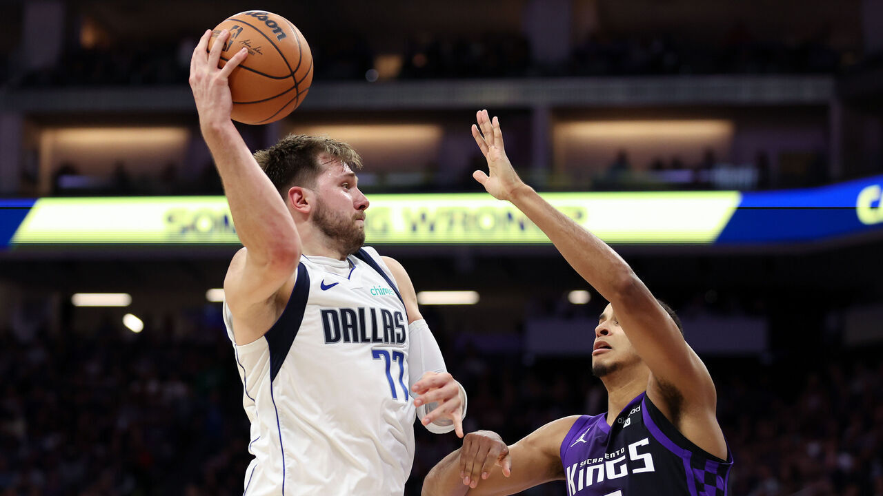 SACRAMENTO, CALIFORNIA - MARCH 26: Luka Doncic #77 of the Dallas Mavericks passes the ball over Keegan Murray #13 of the Sacramento Kings in the second half at Golden 1 Center on March 26, 2024 in Sacramento, California.