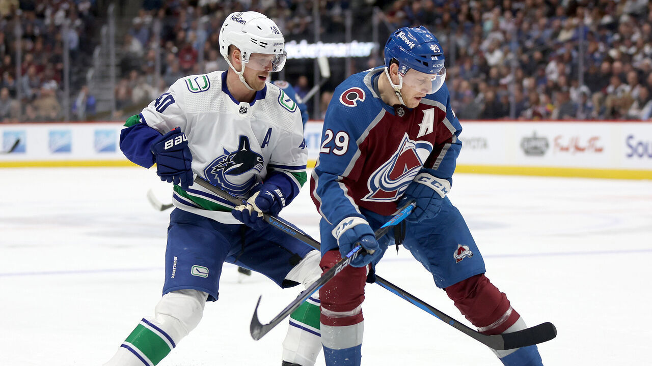 DENVER, COLORADO - FEBRUARY 20: Elias Pettersson #40 of the Vancouver Canucks fights for the puck against Nathan MacKinnon #29 of the Colorado Avalanche in the first period at Ball Arena on February 20, 2024 in Denver, Colorado.
