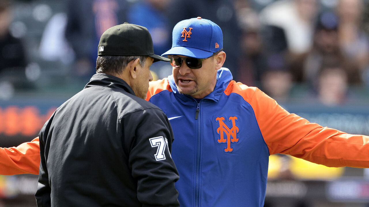 NEW YORK, NEW YORK - MARCH 30: Manager Carlos Mendoza #64 of the New York Mets argues with umpire Alfonso Marquez #72 after pitcher Yohan Ramírez #46 of the New York Mets was ejected for throwing at Rhys Hoskins #12 of the Milwaukee Brewers during the top of the seventh inning at Citi Field on March 30, 2024 in New York City.