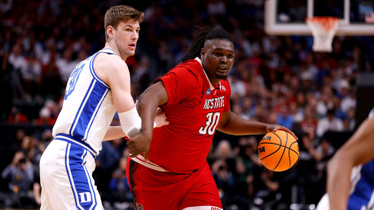 DALLAS, TEXAS - MARCH 31: DJ Burns Jr. #30 of the NC State Wolfpack moves the ball against Kyle Filipowski #30 of the Duke Blue Devils during the first half in the Elite 8 round of the NCAA Men's Basketball Tournament at American Airlines Center on March 31, 2024 in Dallas, Texas.