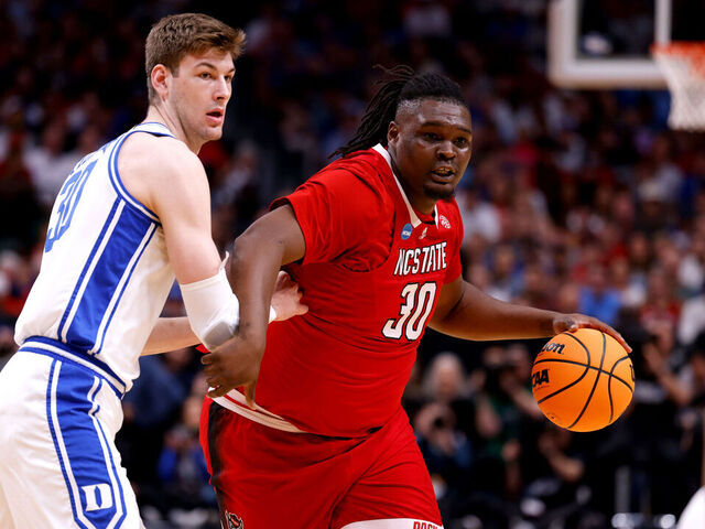DALLAS, TEXAS - MARCH 31: DJ Burns Jr. #30 of the NC State Wolfpack moves the ball against Kyle Filipowski #30 of the Duke Blue Devils during the first half in the Elite 8 round of the NCAA Men's Basketball Tournament at American Airlines Center on March 31, 2024 in Dallas, Texas.