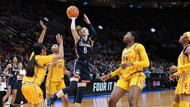 PORTLAND, OR - APRIL 01: UConn Huskies guard Paige Bueckers (5) shoots over USC Trojans guard Kayla Padilla (45) and USC Trojans center Clarice Akunwafo (34) during a 2024 Div I Women's Basketball Championship Elite Eight game between the UConn Huskies and USC Trojans on April 1, 2024 at Moda Center in Portland, Oregon.