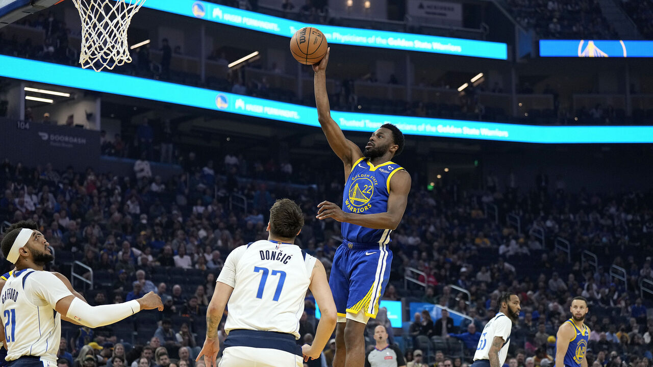 SAN FRANCISCO, CALIFORNIA - APRIL 02: Andrew Wiggins #22 of the Golden State Warriors shoots against Luka Doncic #77 of the Dallas Mavericks during the first half at Chase Center on April 02, 2024 in San Francisco, California.