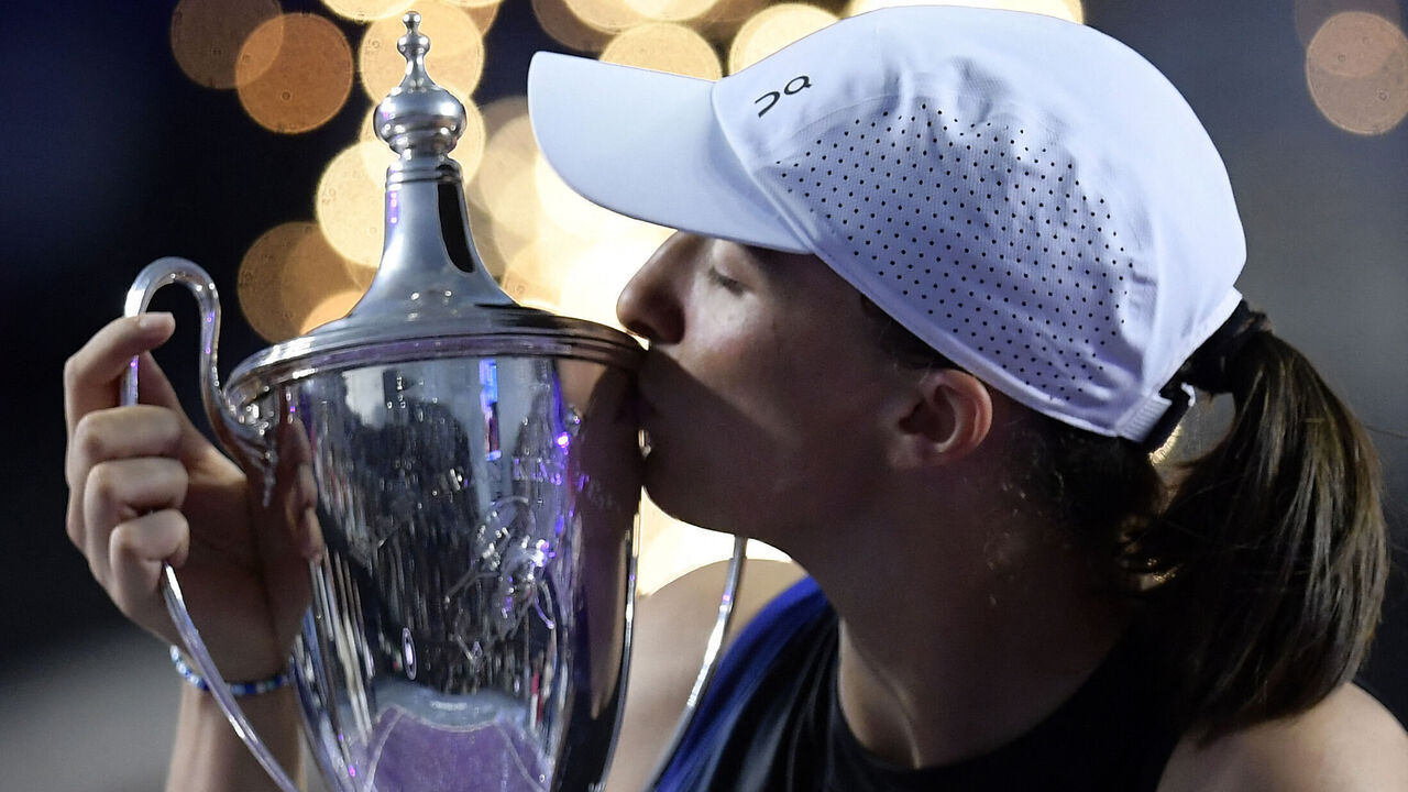 TOPSHOT - Poland's Iga Swiatek kisses her trophy on the podium after winning the WTA Finals Championship women's singles final tennis match in Cancun, Mexico on November 6, 2023.