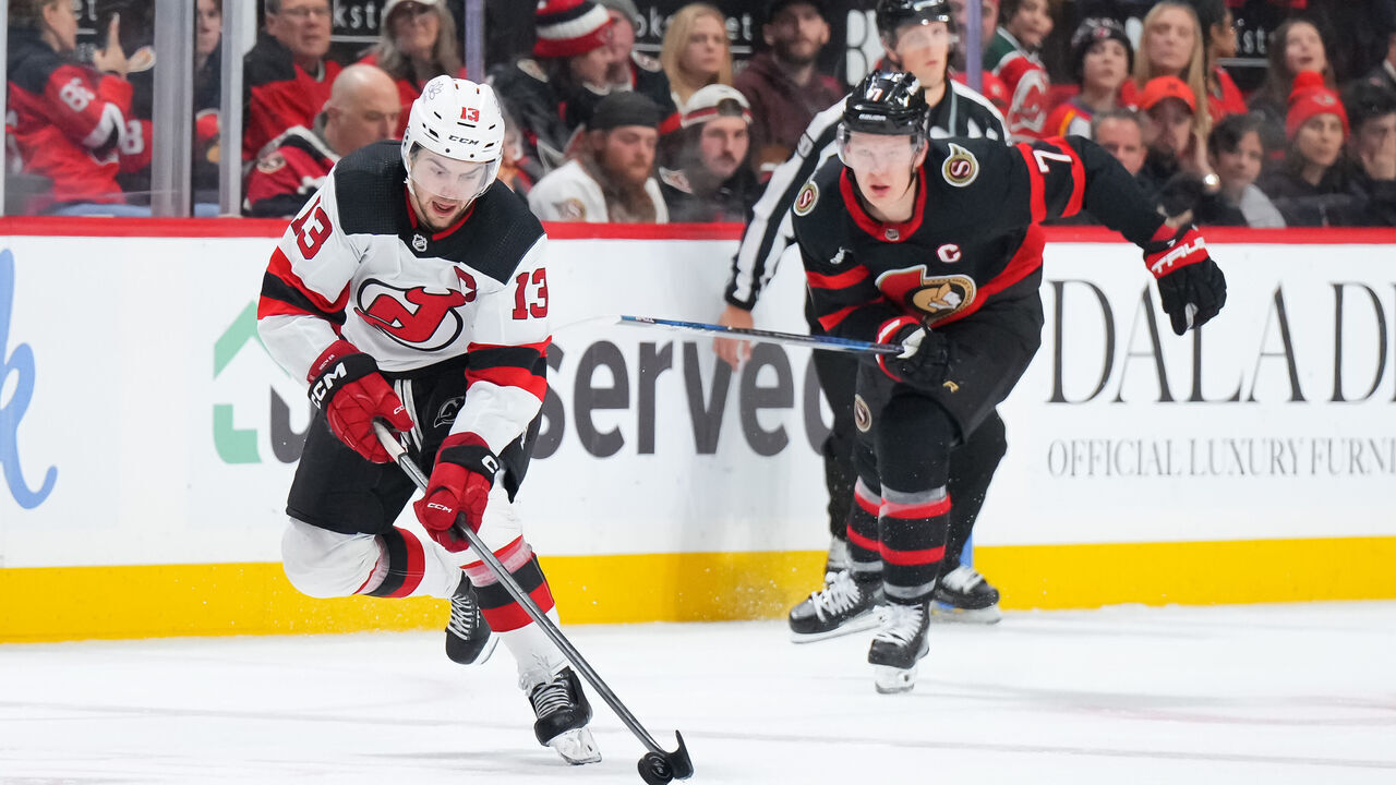 OTTAWA, CANADA - DECEMBER 29: Nico Hischier #13 of the New Jersey Devils skates up ice with the puck against Brady Tkachuk #7 of the Ottawa Senators at Canadian Tire Centre on December 29, 2023 in Ottawa, Ontario, Canada.