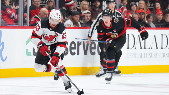 OTTAWA, CANADA - DECEMBER 29: Nico Hischier #13 of the New Jersey Devils skates up ice with the puck against Brady Tkachuk #7 of the Ottawa Senators at Canadian Tire Centre on December 29, 2023 in Ottawa, Ontario, Canada.