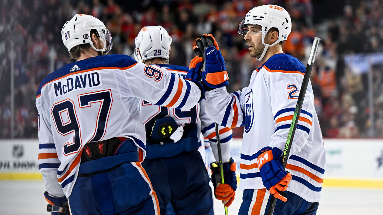 CALGARY, AB - APRIL 06: Edmonton Oilers Defenceman Evan Bouchard (2) celebrates a goal with Edmonton Oilers Center Connor McDavid (97) during the third period of an NHL game between the Calgary Flames and the Edmonton Oilers on April 6, 2024, at the Scotiabank Saddledome in Calgary, AB.