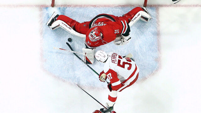 RALEIGH, NORTH CAROLINA - MARCH 28: Frederik Andersen #31 of the Carolina Hurricanes makes a save against David Perron #57 of the Detroit Red Wings during the first period of the game at PNC Arena on March 28, 2024 in Raleigh, North Carolina.