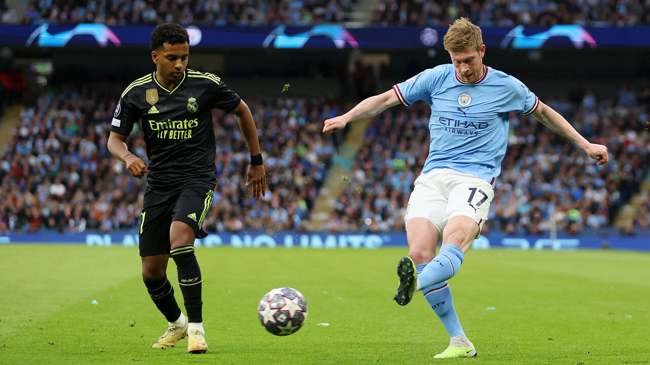 MANCHESTER, ENGLAND - MAY 17: Kevin De Bruyne of Manchester City crosses the ball past Rodrygo of Real Madrid during the UEFA Champions League semi-final second leg match between Manchester City FC and Real Madrid at Etihad Stadium on May 17, 2023 in Manchester, England.