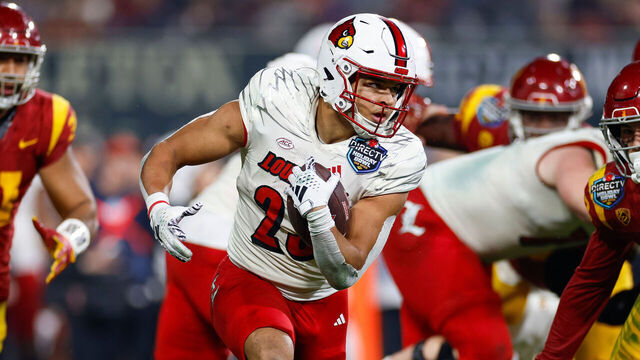 SAN DIEGO, CALIFORNIA - DECEMBER 27: Isaac Guerendo #23 of the Louisville Cardinals runs with the ball during the DIRECTV Holiday Bowl game against the USC Trojans at Petco Park on December 27, 2023 in San Diego, California.