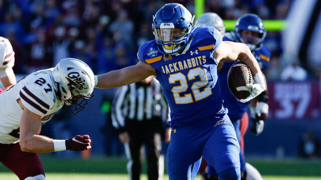 FRISCO, TEXAS - JANUARY 07: Isaiah Davis #22 of the South Dakota State Jackrabbits stiff arms Trevin Gradney #27 of the Montana Grizzlies during the Division I FCS Football Championship held at Toyota Stadium on January 7, 2024 in Frisco, Texas.