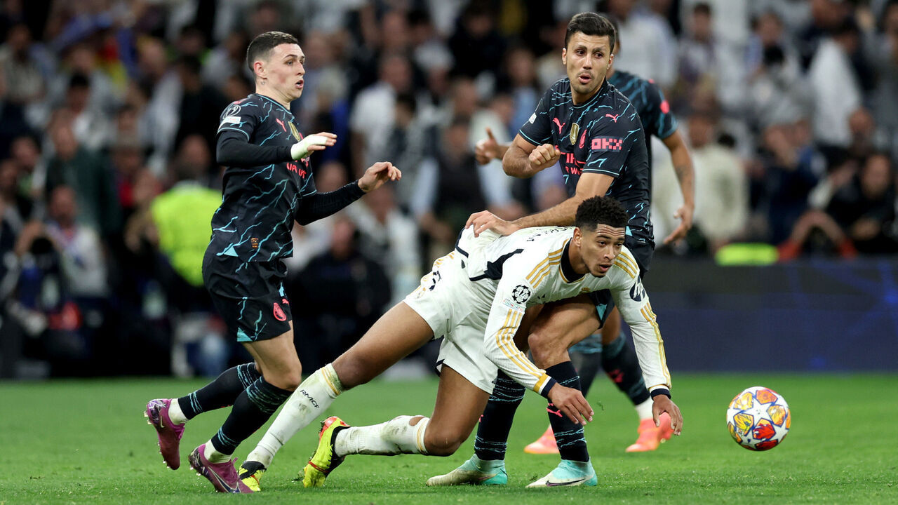 MADRID, SPAIN - APRIL 09: Jude Bellingham of Real Madrid is challenged by Phil Foden and Rodri of Manchester City during the UEFA Champions League quarter-final first leg match between Real Madrid CF and Manchester City at Estadio Santiago Bernabeu on April 09, 2024 in Madrid, Spain.