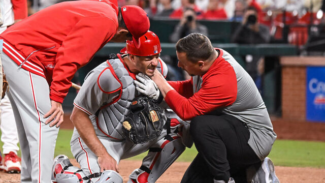 ST. LOUIS, MO - Apr 9: Philadelphia Phillies catcher J.T. Realmuto (10) has his collar bone checked by the team trainer while Philadelphia Phillies manager Rob Thomson (59) checks in on him during a game between the Philadelphia Phillies and the St. Louis Cardinals on Tuesday April 9, 2024, at Busch Stadium in St. Louis MO
