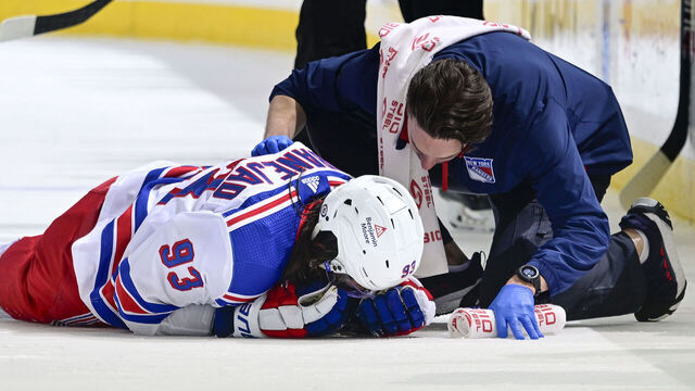 ELMONT, NEW YORK - APRIL 09: Mika Zibanejad #93 of the New York Rangers is tended to by the trainer during the third period against the New York Islanders at UBS Arena on April 09, 2024 in Elmont, New York.