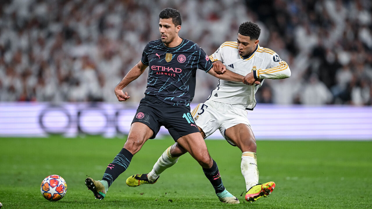MADRID, SPAIN - APRIL 9: Rodri of Manchester City and Jude Bellingham of Real Madrid CF battle for the ball during the UEFA Champions League quarter-final first leg match between Real Madrid CF and Manchester City at Estadio Santiago Bernabeu on April 9, 2024 in Madrid, Spain.