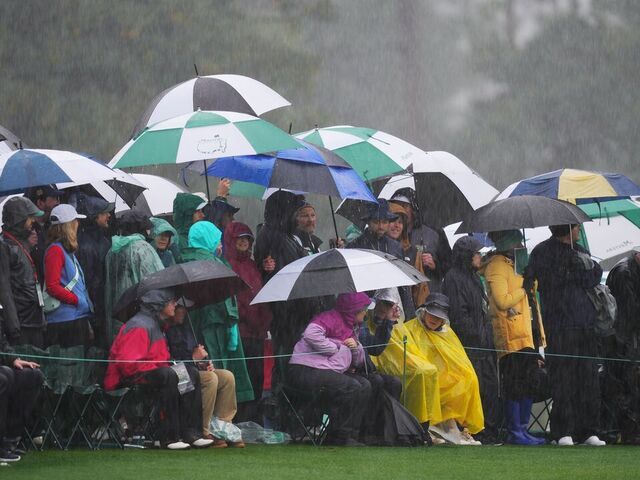 Audience watch the match in the rain during the second round of the 2023 Masters golf tournament at Augusta National Golf Club in Augusta, the United States, on April 8, 2023.