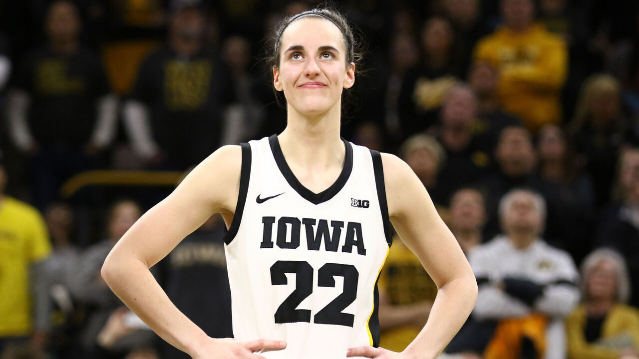 IOWA CITY, IOWA- FEBRUARY 15: Guard Caitlin Clark #22 of the Iowa Hawkeyes listens as the crowd cheers after breaking the NCAA women's all-time scoring record during the game against the Michigan Wolverines at Carver-Hawkeye Arena on February 15, 2024 in Iowa City, Iowa.
