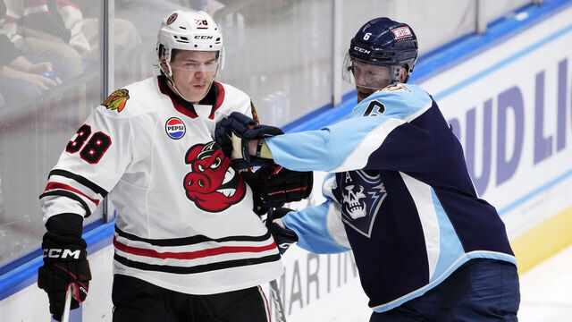 ROCKFORD, ILLINOIS - NOVEMBER 17: Luke Prokop #6 of the Milwaukee Admirals checks Ethan Del Mastro #38 of the Rockford Icehogs during the third period at BMO Harris Bank Center on November 17, 2023 in Rockford, Illinois. Prokop, the first openly gay ice hockey player to play in a North American professional league, is making his AHL debut.