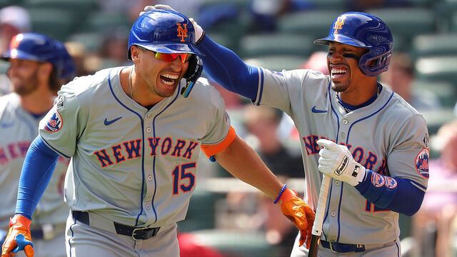 ATLANTA, GEORGIA - APRIL 11: Tyrone Taylor #15 of the New York Mets reacts with Francisco Lindor #12 after hitting a grand slam in the ninth inning against the Atlanta Braves at Truist Park on April 11, 2024 in Atlanta, Georgia.