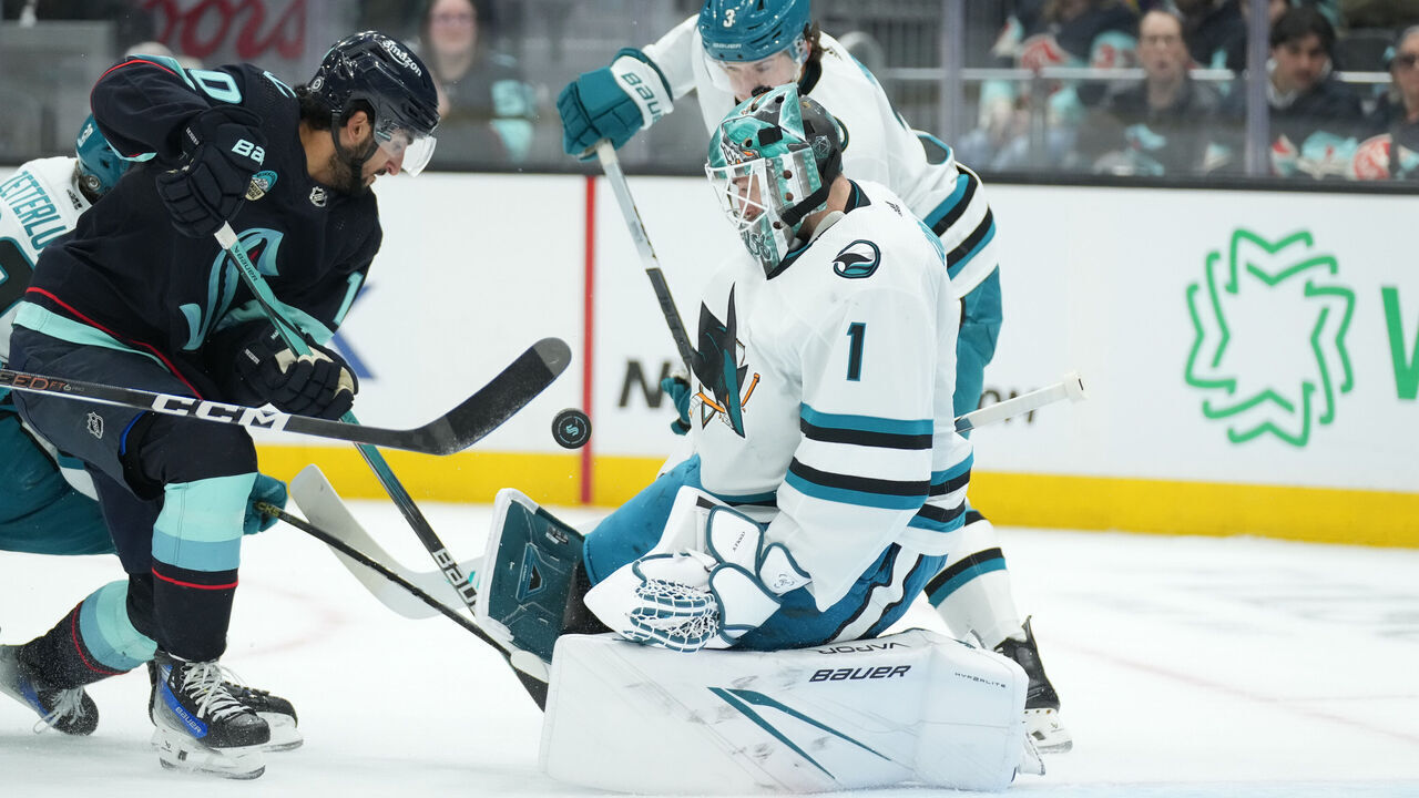 SEATTLE, WA - APRIL 11: San Jose Sharks goaltender Devin Cooley (1) deflects a Seattle Kraken center Matty Beniers (10) shot during an NHL game between the San Jose Sharks and the Seattle Kraken on April 11, 2024 at Climate Pledge Arena in Seattle, WA.