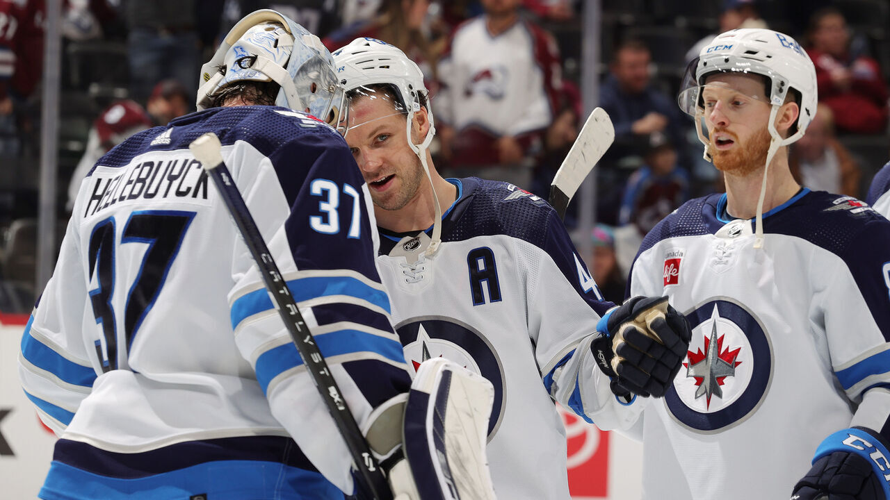 DENVER, COLORADO - APRIL 13: Goaltender Connor Hellebuyck #37, Josh Morrissey #44 and Kyle Connor #81 of the Winnipeg Jets celebrate a 7-0 win against the Colorado Avalanche at Ball Arena on April 13, 2024 in Denver, Colorado.