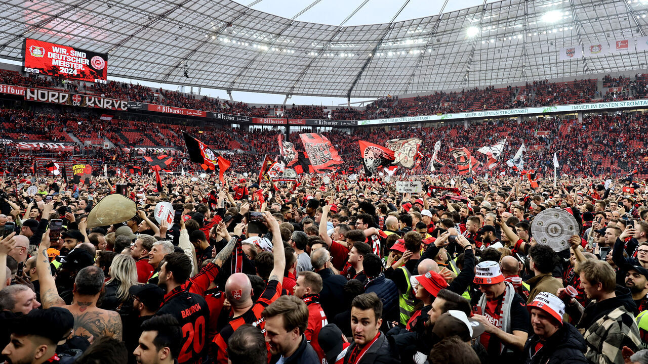 LEVERKUSEN, GERMANY - APRIL 14: Fans of Bayer Leverkusen invade the pitch and celebrate after their team's victory and winning the Bundesliga title for the first time in their history in the Bundesliga match between Bayer 04 Leverkusen and SV Werder Bremen at BayArena on April 14, 2024 in Leverkusen, Germany.
