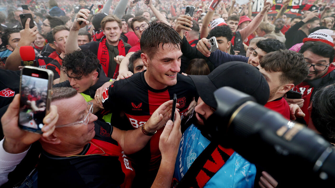 LEVERKUSEN, GERMANY - APRIL 14: Patrik Schick of Bayer Leverkusen celebrates with fans who have invaded the pitch after the team's victory and winning the Bundesliga title for the first time in their history in the Bundesliga match between Bayer 04 Leverkusen and SV Werder Bremen at BayArena on April 14, 2024 in Leverkusen, Germany.
