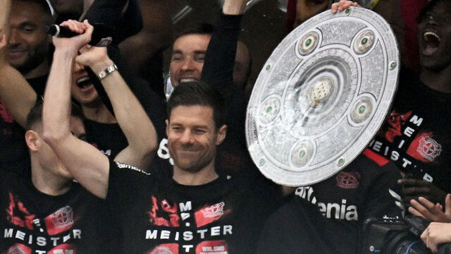 14 April 2024, North Rhine-Westphalia, Leverkusen: Soccer, Bundesliga, Bayer 04 Leverkusen - SV Werder Bremen, Matchday 29, BayArena. The Leverkusen team around coach Xabi Alonso cheers with a stylized championship trophy from the stands into the stadium to the fans who stormed the pitch after the victory. IMPORTANT NOTE: In accordance with the regulations of the DFL German Football League and the DFB German Football Association, it is prohibited to exploit or have exploited photographs taken in the stadium and/or of the match in the form of sequential images and/or video-like photo series. Photo: Federico Gambarini/dpa