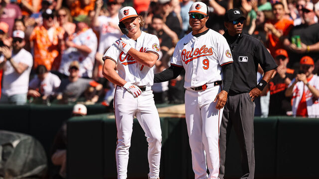 BALTIMORE, MD - APRIL 14: Jackson Holliday #7 of the Baltimore Orioles reacts with Anthony Sanders #9 after hitting a single for his first career MLB hit during the seventh inning of the game against the Milwaukee Brewers at Oriole Park at Camden Yards on April 14, 2024 in Baltimore, Maryland.