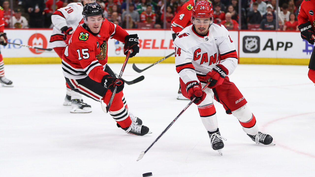 CHICAGO, IL - APRIL 14: Seth Jarvis #24 of the Carolina Hurricanes controls the puck against Joey Anderson #15 of the Chicago Blackhawks during the second period at the United Center on April 14, 2024 in Chicago, Illinois.