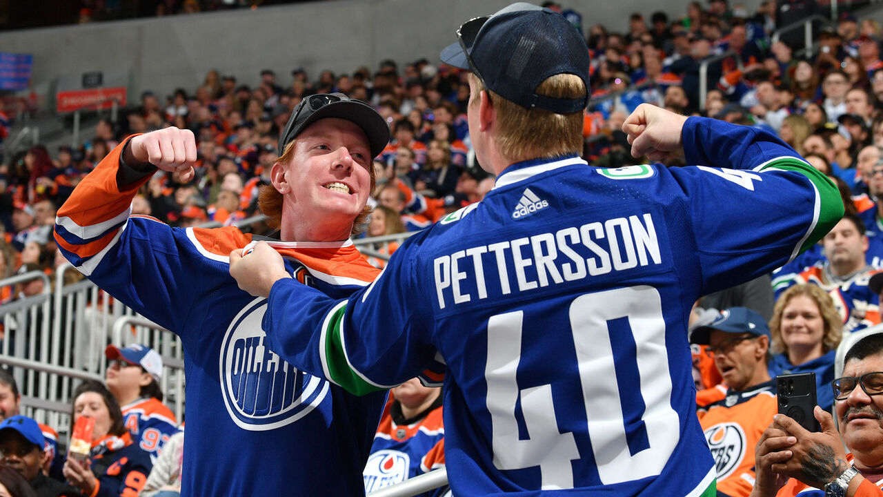 EDMONTON, CANADA - APRIL 13: An Edmonton Oilers fan and Vancouver Canucks fan pose for a photo at Rogers Place on April 13, 2024, in Edmonton, Alberta, Canada.
