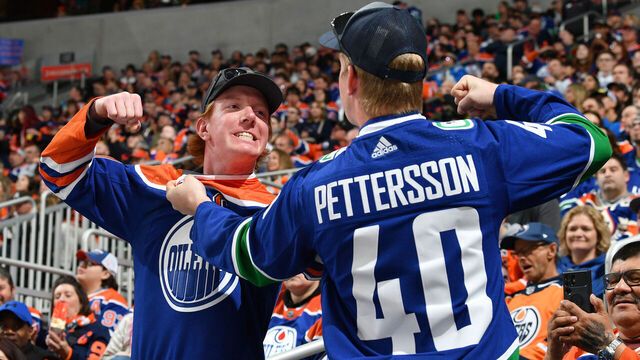 EDMONTON, CANADA - APRIL 13: An Edmonton Oilers fan and Vancouver Canucks fan pose for a photo at Rogers Place on April 13, 2024, in Edmonton, Alberta, Canada.