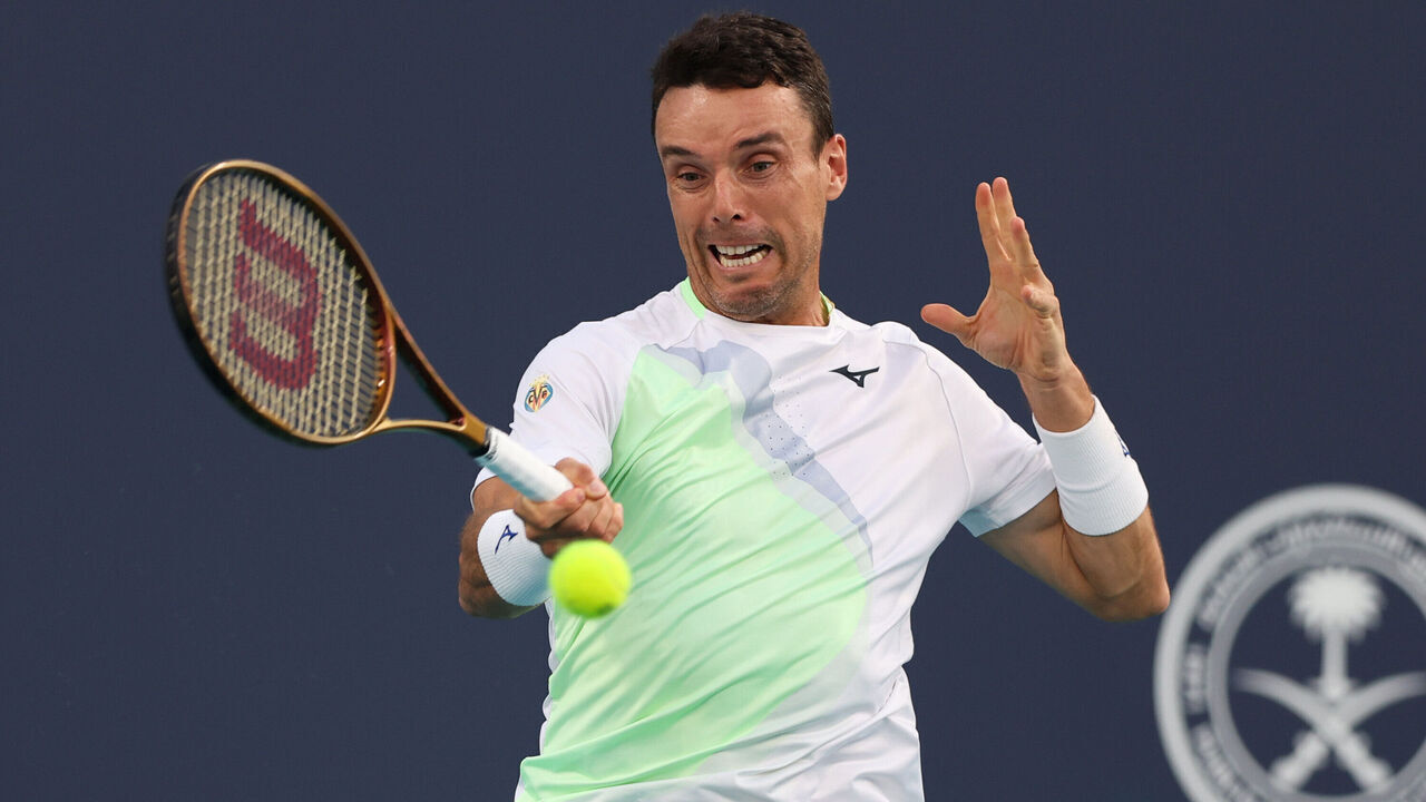 MIAMI GARDENS, FLORIDA - MARCH 21: Roberto Bautista Agut of Spain returns a shot to Emilio Nava of the United States during his men's singles match during the Miami Open at Hard Rock Stadium on March 21, 2024 in Miami Gardens, Florida.
