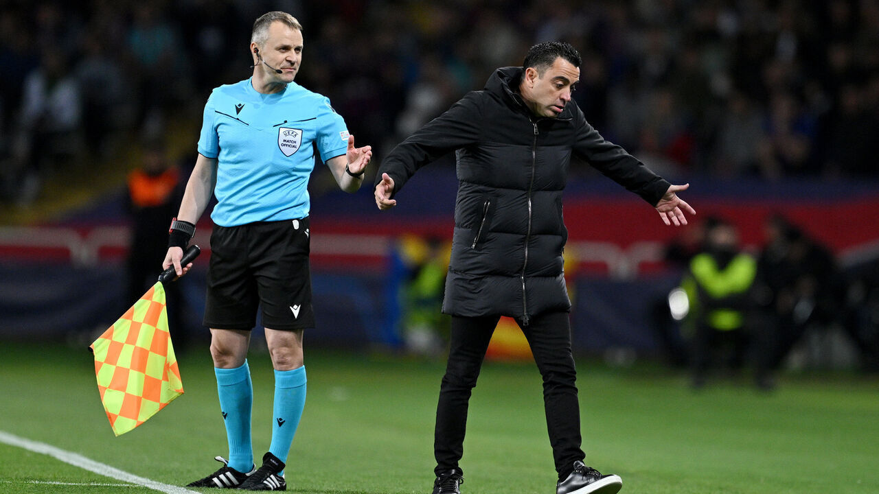 BARCELONA, SPAIN - APRIL 16: Xavi, Head Coach of FC Barcelona, reacts towards Assistant Referee Vasile Florin Marinescu after Ronald Araujo of FC Barcelona (not pictured) is shown a red card during the UEFA Champions League quarter-final second leg match between FC Barcelona and Paris Saint-Germain at Estadi Olimpic Lluis Companys on April 16, 2024 in Barcelona, Spain.