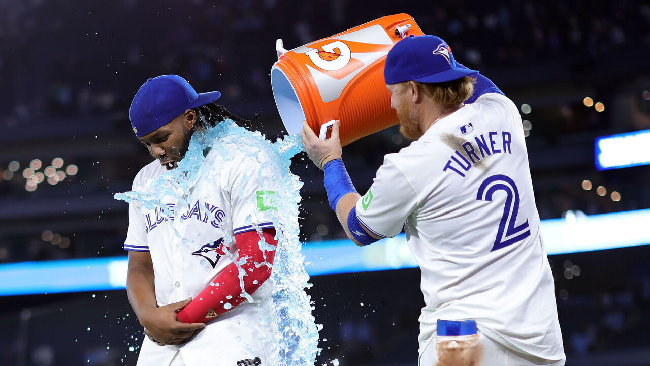 TORONTO, ON - APRIL 16: Vladimir Guerrero Jr. #27 of the Toronto Blue Jays is doused with sports drink by Justin Turner #2 following a 5-4 win against the New York Yankees at Rogers Centre on April 16, 2024 in Toronto, Ontario, Canada.