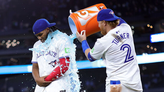 TORONTO, ON - APRIL 16: Vladimir Guerrero Jr. #27 of the Toronto Blue Jays is doused with sports drink by Justin Turner #2 following a 5-4 win against the New York Yankees at Rogers Centre on April 16, 2024 in Toronto, Ontario, Canada.