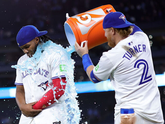 TORONTO, ON - APRIL 16: Vladimir Guerrero Jr. #27 of the Toronto Blue Jays is doused with sports drink by Justin Turner #2 following a 5-4 win against the New York Yankees at Rogers Centre on April 16, 2024 in Toronto, Ontario, Canada.