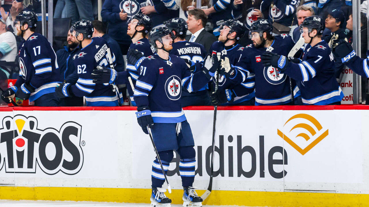 WINNIPEG, CANADA - APRIL 16: Kyle Connor #81 of the Winnipeg Jets celebrates his first period goal against the Seattle Kraken with teammates at the bench at the Canada Life Centre on April 16, 2024 in Winnipeg, Manitoba, Canada.