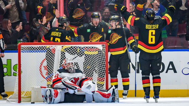 VANCOUVER, CANADA - DECEMBER 5: Nils Hoglander #21 is congratulated by J.T. Miller #9 Quinn Hughes #43 and Brock Boeser #6 of the Vancouver Canucks after scoring a goal on Vitek Vanecek #41 of the New Jersey Devils during the third period of their NHL game at Rogers Arena on December 5, 2023 in Vancouver, British Columbia, Canada.