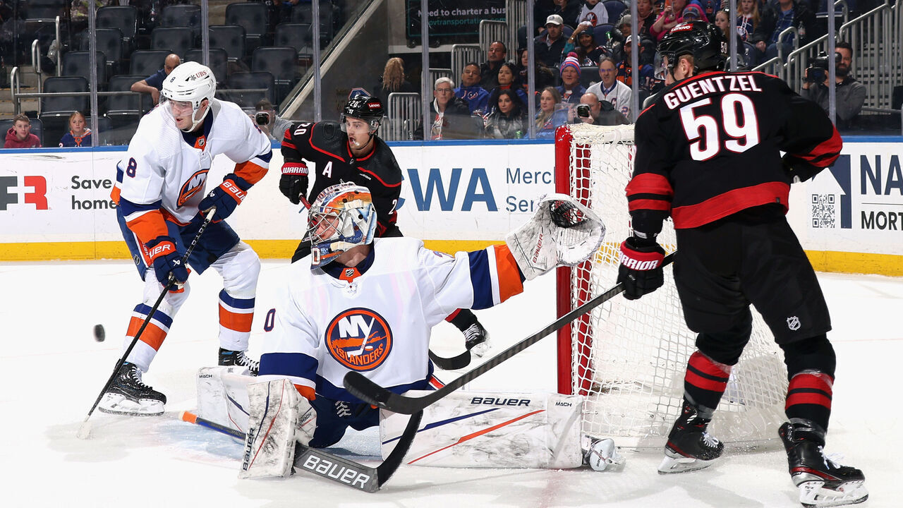 ELMONT, NEW YORK - MARCH 19: The New York Islanders defend against Sebastian Aho #20 and Jake Guentzel #59 of the Carolina Hurricanes during the first period at UBS Arena on March 19, 2024 in Elmont, New York.