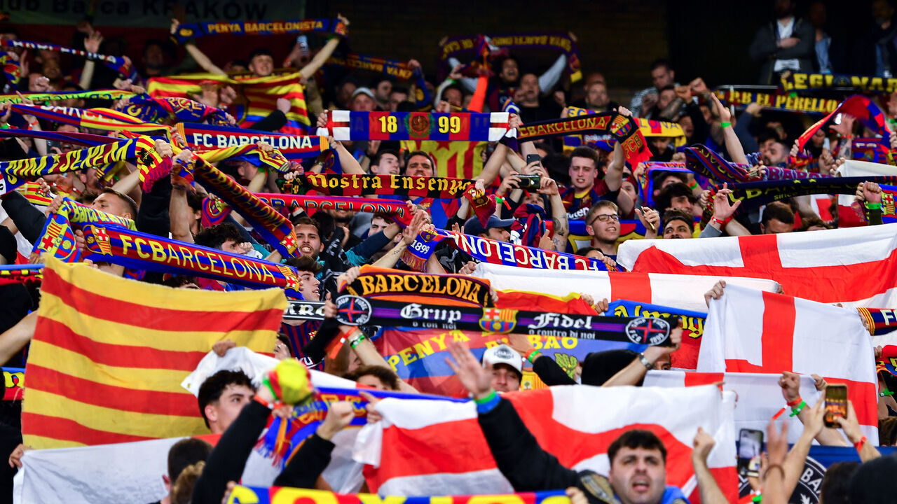 PARIS, FRANCE - APRIL 10: Fans of FC Barcelona show their support with scarves during the UEFA Champions League quarter-final first leg match between Paris Saint-Germain and FC Barcelona at Parc des Princes on April 10, 2024 in Paris, France.