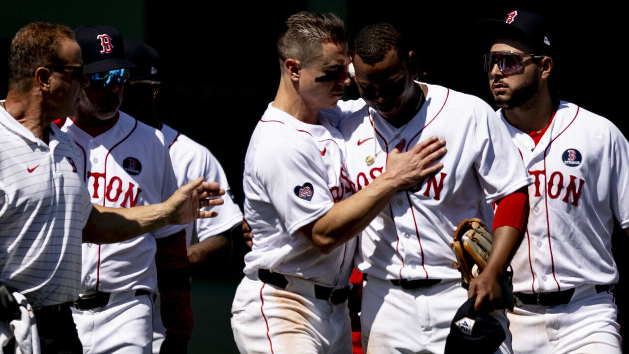 BOSTON, MA - APRIL 15: Tyler O'Neill #17 of the Boston Red Sox and Rafael Devers #11 of the Boston Red Sox walk off the field with trainers after colliding during the seventh inning of a game against the Cleveland Guardians on April 15, 2024 at Fenway Park in Boston, Massachusetts.