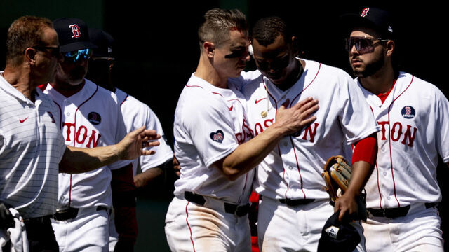 BOSTON, MA - APRIL 15: Tyler O'Neill #17 of the Boston Red Sox and Rafael Devers #11 of the Boston Red Sox walk off the field with trainers after colliding during the seventh inning of a game against the Cleveland Guardians on April 15, 2024 at Fenway Park in Boston, Massachusetts.