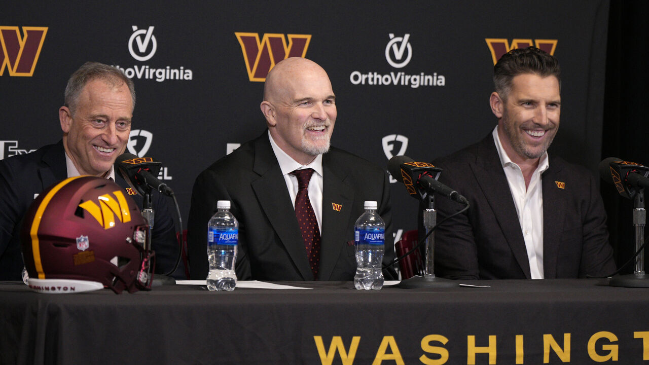 ASHBURN, VIRGINIA - FEBRUARY 05: Head coach Dan Quinn of the Washington Commanders speaks during a press conference alongside managing partner Josh Harris, left, and general manager Adam Peters at OrthoVirginia Training Center at Commanders Park on February 05, 2024 in Ashburn, Virginia.