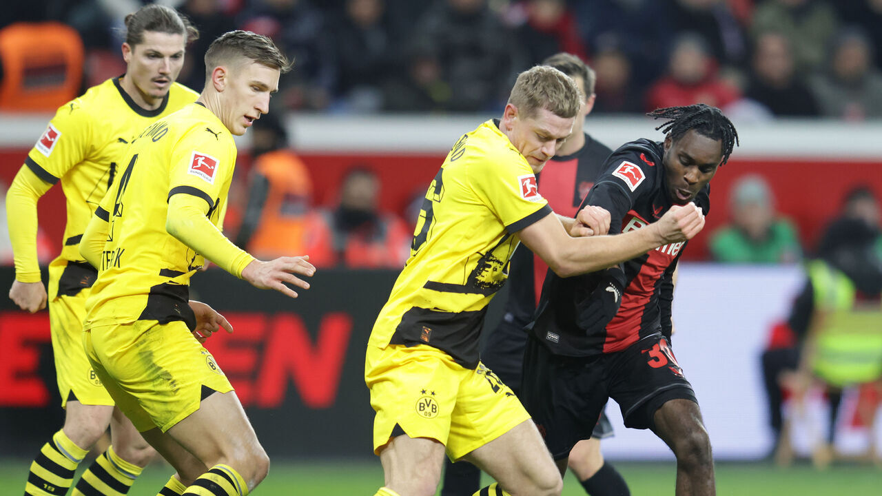LEVERKUSEN, GERMANY - DECEMBER 3: (L.R.) Nico Schlotterbeck and Julian Ryerson of Dortmund and Jeremie Frimpong of Bayer battle for the ball during the Bundesliga match between Bayer 04 Leverkusen and Borussia Dortmund at BayArena on December 3, 2023 in Leverkusen, Germany.