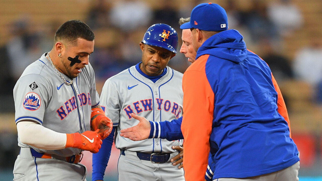 LOS ANGELES, CA - APRIL 19: New York Mets catcher Francisco Alvarez (4) is looked at by first base coach Antoan Richardson and the trainer after being injured during the MLB game between the New York Mets and the Los Angeles Dodgers on April 19, 2024 at Dodger Stadium in Los Angeles, CA.